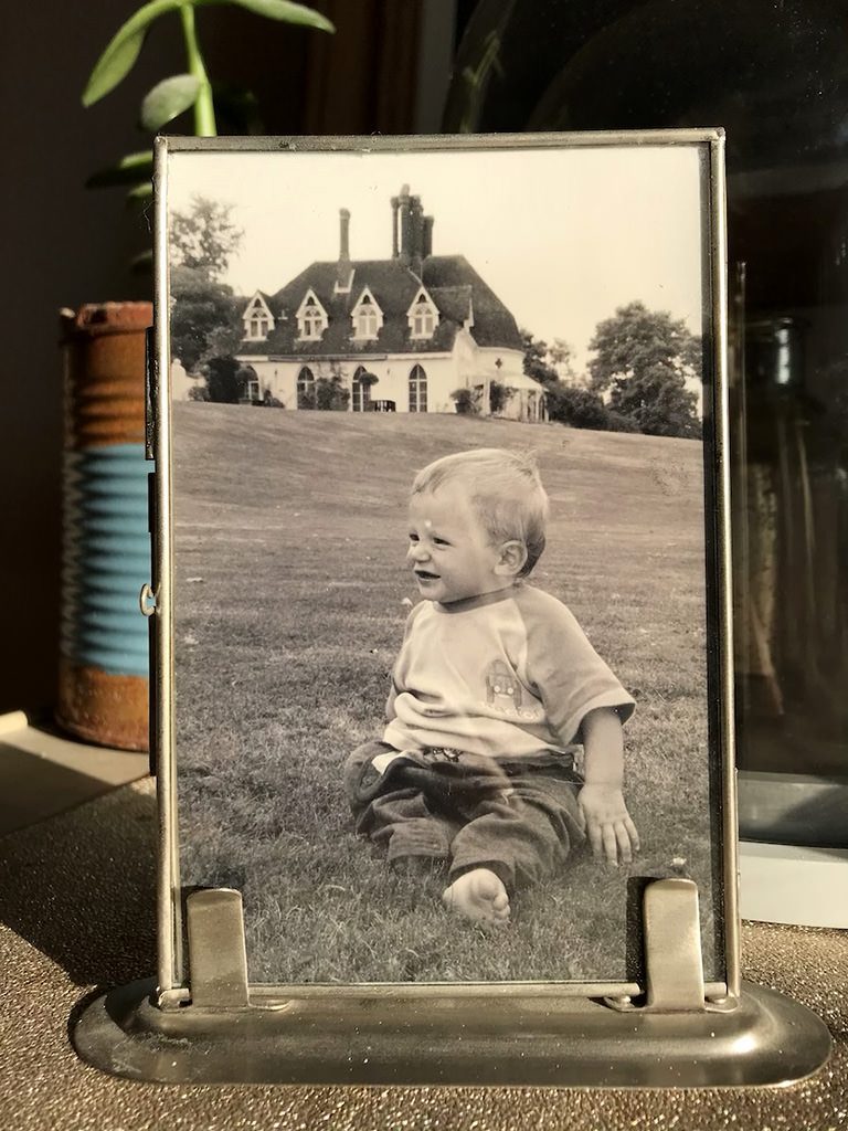 Little boy sat on the lawn at Houghton Lodge